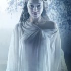 Digital art portrait of figure with pale blue hair and eyes, silver necklace, white cloak, snowy forest