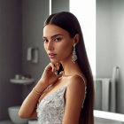 Elegant woman in beaded dress poses by mirror in dimly lit room