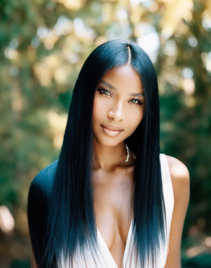 Portrait of Woman with Long Straight Black Hair and Hoop Earrings in White Top against Green Foli