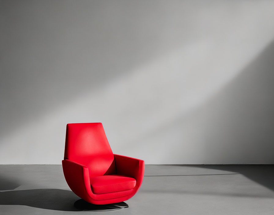 Red Modern Armchair in Room with Grey Floor and White Wall under Dramatic Lighting