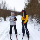 Animated characters in snowy forest with staff and sword, dressed in winter attire