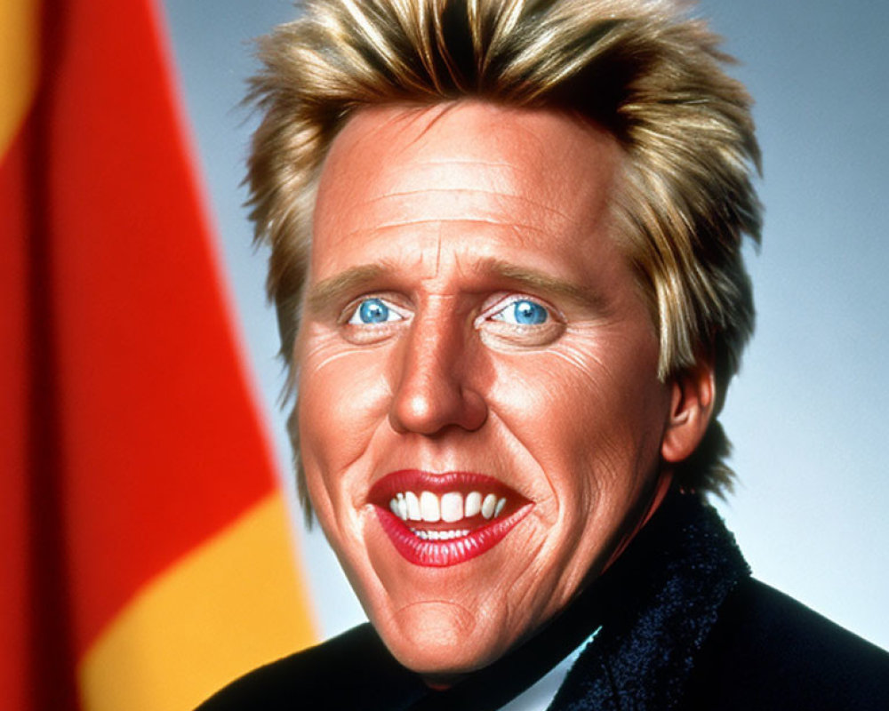 Blonde man in dark blazer smiles against red and yellow backdrop