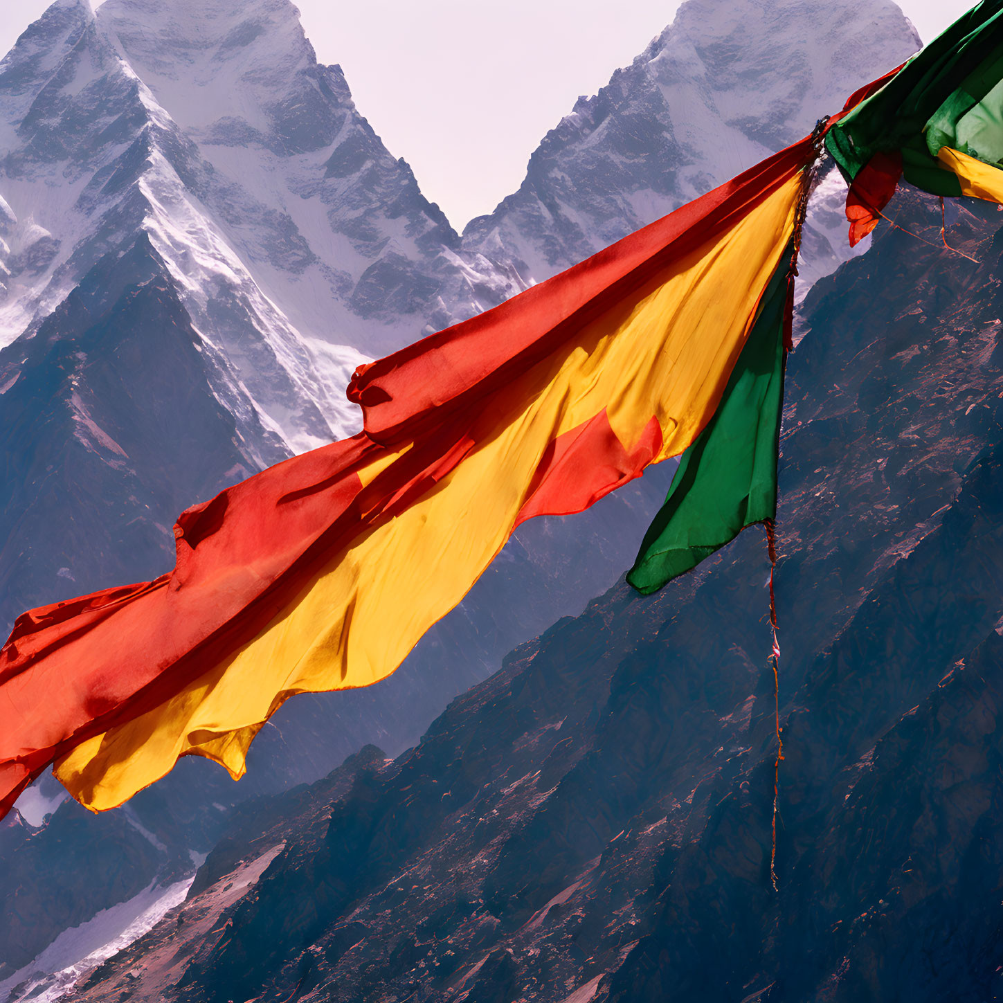 Vibrant prayer flags against snowy mountain peaks