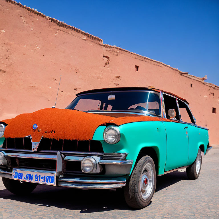 Vintage Turquoise Car with Red Fabric Cover Parked by Terracotta Wall