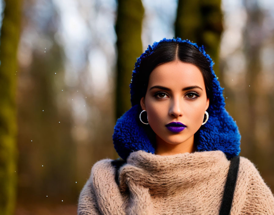 Dark-haired woman in beige coat and blue knit cap in forest setting