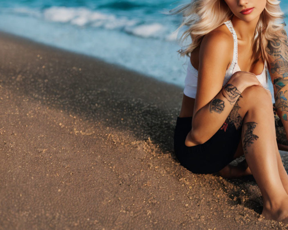 Blonde Woman with Tattoos on Sandy Beach by Ocean