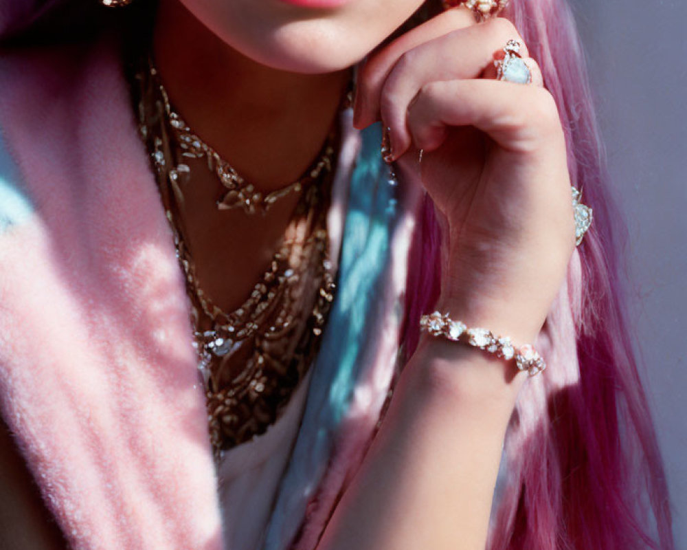 Pink-haired person in pastel fur coat with gold jewelry against soft background.