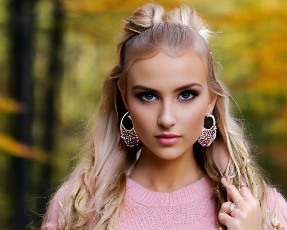 Blonde Woman with Braided Hair and Earrings in Pink Sweater by Autumn Trees