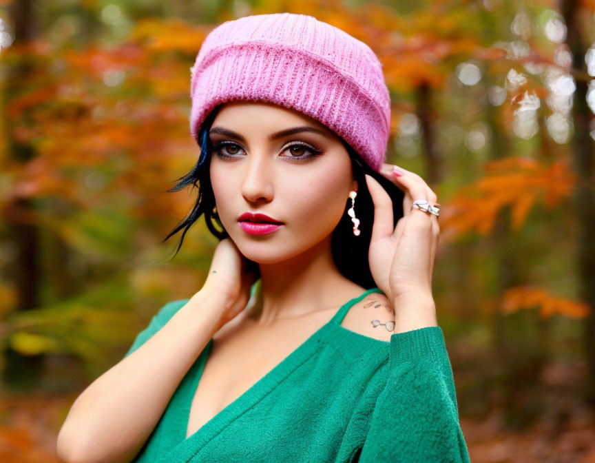 Dark-Haired Woman in Pink Beanie and Green Sweater in Autumn Forest