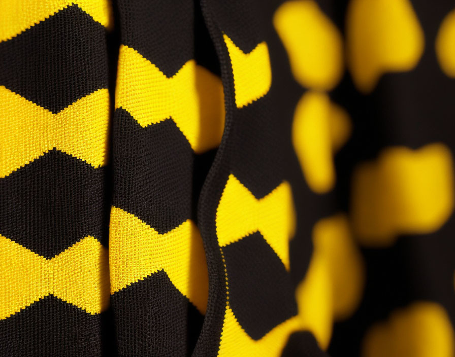 Yellow and black patterned fabric close-up with intersecting geometric shapes