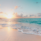 Tranquil beach sunset with warm glow and gentle waves