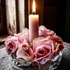 Pink candle with roses and candles in glass bowl setting