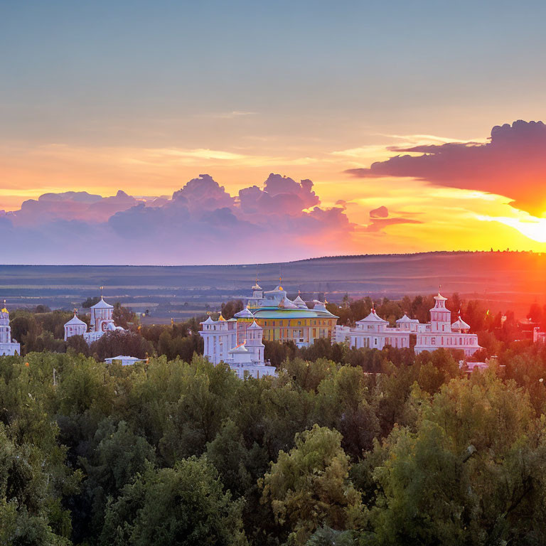 Sunset over elegant buildings and lush green landscape with cloudy sky