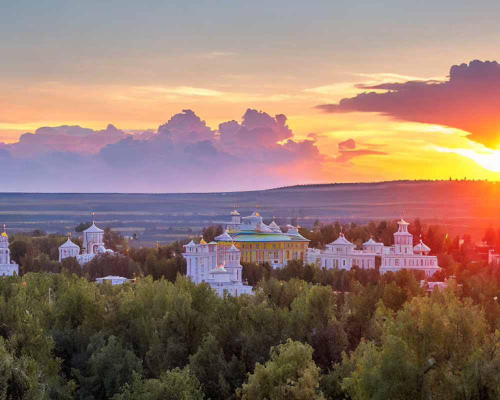 Sunset over elegant buildings and lush green landscape with cloudy sky