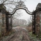 Ornate open gate to lush green hills and pink skies