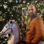 Bearded warrior in armor with spear beside white horse under starry sky