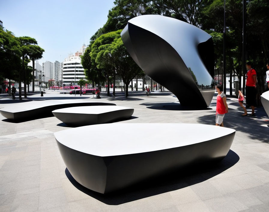 Modern benches and sculptures in a sunny public space.