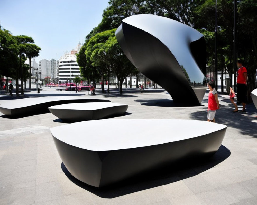 Modern benches and sculptures in a sunny public space.