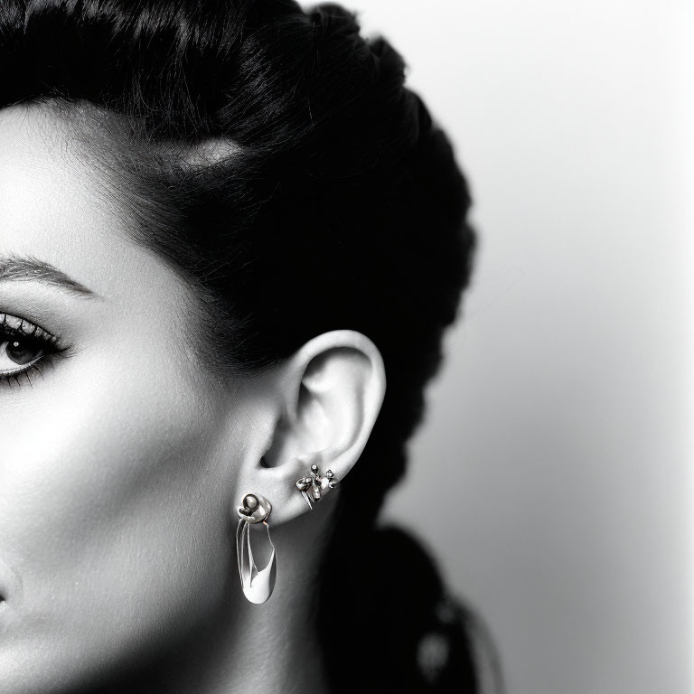 Monochrome profile portrait of woman with intricate hairstyle and elegant earrings