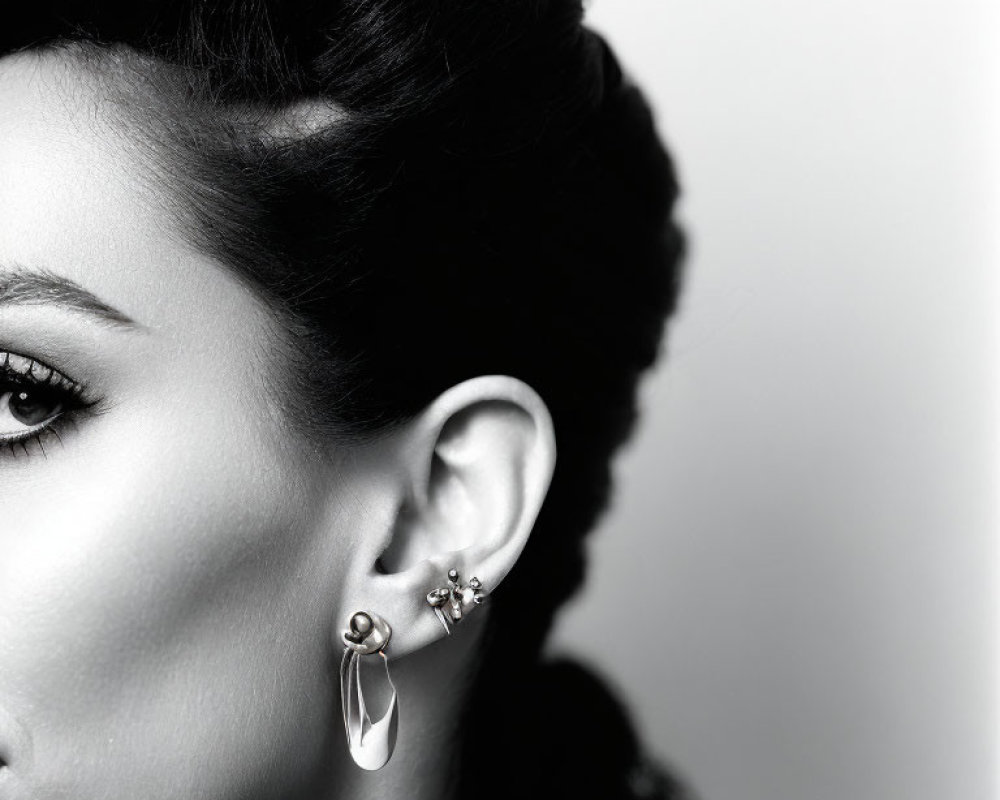 Monochrome profile portrait of woman with intricate hairstyle and elegant earrings