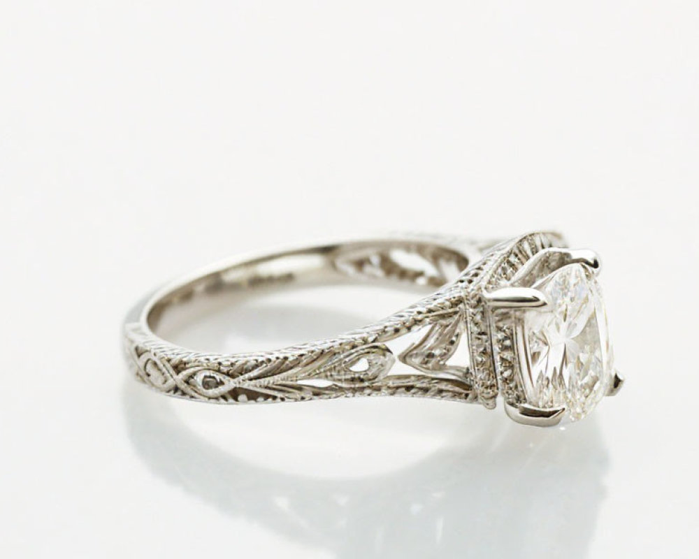 Silver Ring with Filigree Design & Solitaire Diamond on Reflective Surface