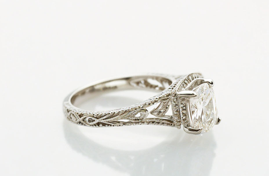 Silver Ring with Filigree Design & Solitaire Diamond on Reflective Surface