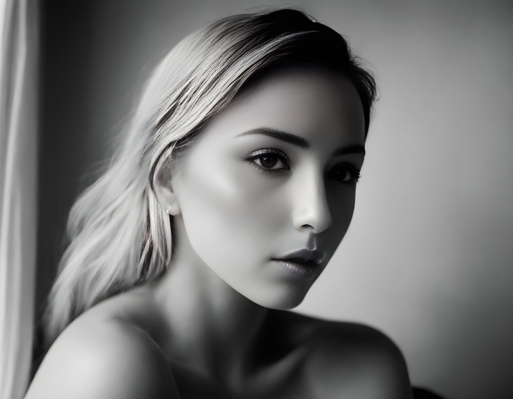 Monochromatic portrait of woman with bare shoulders and intense gaze