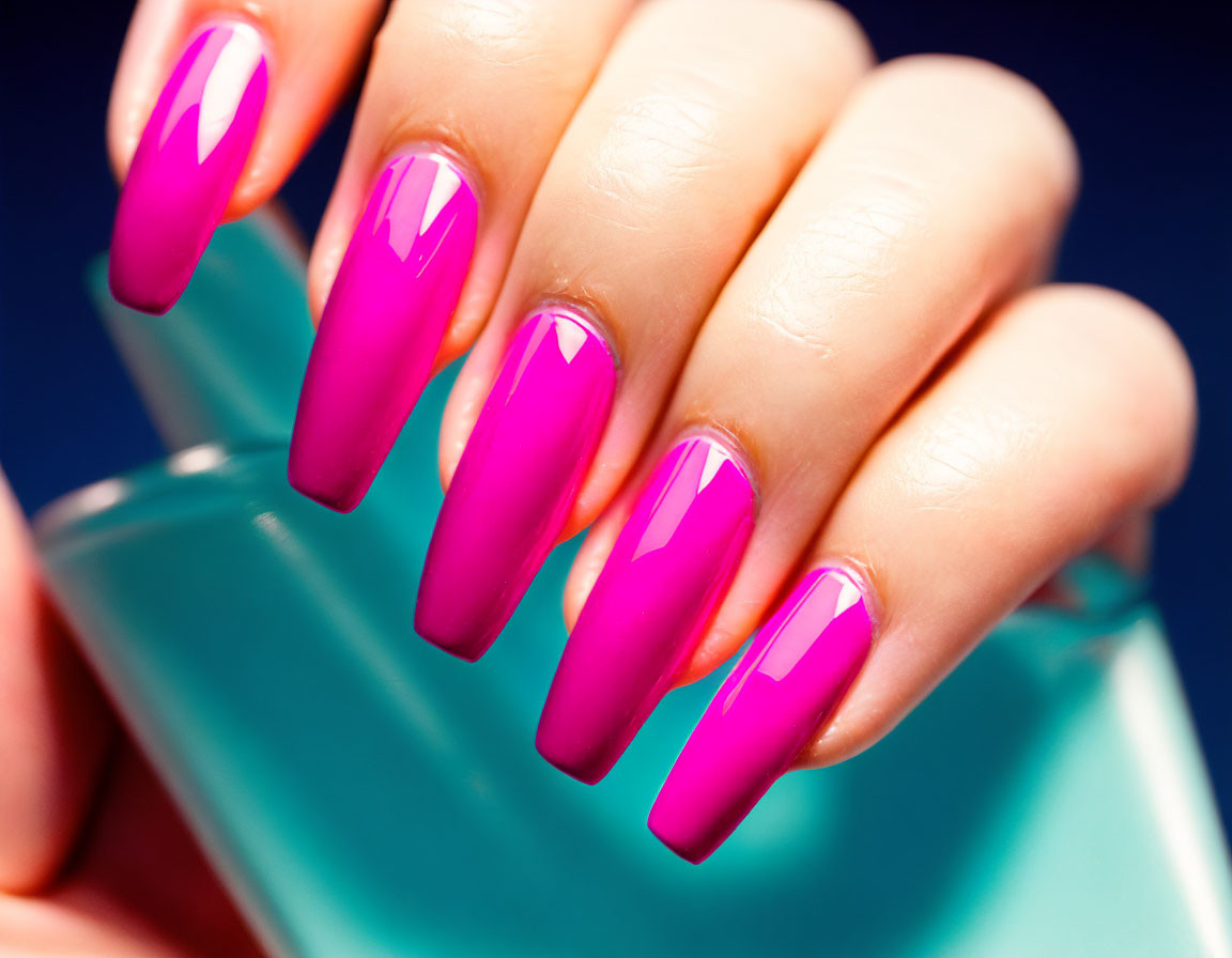 Detailed Close-Up of Pink Stiletto Nails on Turquoise Background