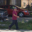 Person in Maroon Suit and Mask Walking Past Vintage Fire Truck and Personnel