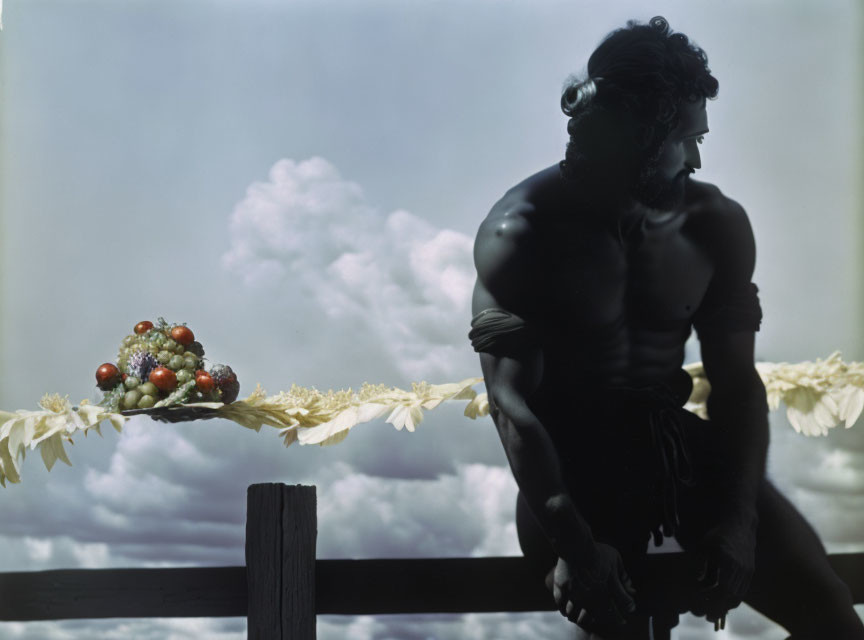 Curly-Haired Man Sitting Shirtless with Fruit Bowl on Wooden Ledge