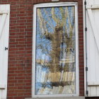 Symmetrical blue, gold, and cream window design on red brick wall