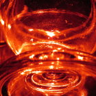 Close-up of Cognac Glass with Galaxy-Like Liquid on Warm Bokeh Background