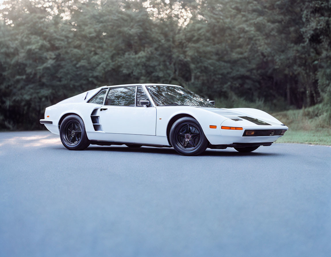 Vintage White Sports Car with Pop-Up Headlights on Asphalt Road