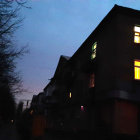 Cozy house with warm yellow-lit windows and blue star-shaped lights at night