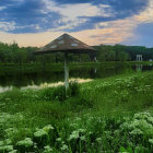 Futuristic building with geometric glass facade and sunset reflection in greenery and pond