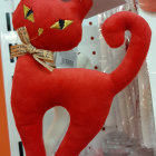 Red Stylized Cat Figurine with Floral Patterns on Orange Background