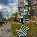 Whimsical fantasy village scene with pastel buildings, cobblestone path, flowering tree, bench