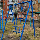 Colorful painting of swing set in floral garden with urban backdrop