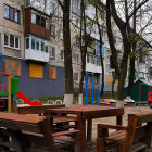 Winter balcony scene with wooden table set overlooking snowy urban buildings.