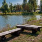 Scenic landscape painting with waterfall, boat, benches, and cottage.