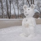 Peaceful anthropomorphic bear on icy pond in snowy winter forest