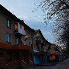 Tranquil street at twilight with townhouses, street lights, and silhouetted birds