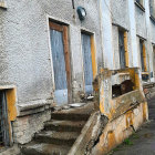 Picturesque cobblestone street with blue-doored homes and floral decor.