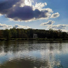 River reflecting sun, clouds, colorful circles, lush greenery, blue sky