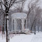 Snowy Pavilion Surrounded by Frost-Covered Trees in Winter Landscape