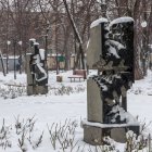 Snow-covered forest with marble woman's face sculpture in serene setting