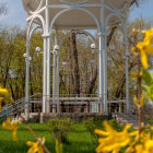 Tranquil garden with white gazebo and vibrant flowers under clear sky