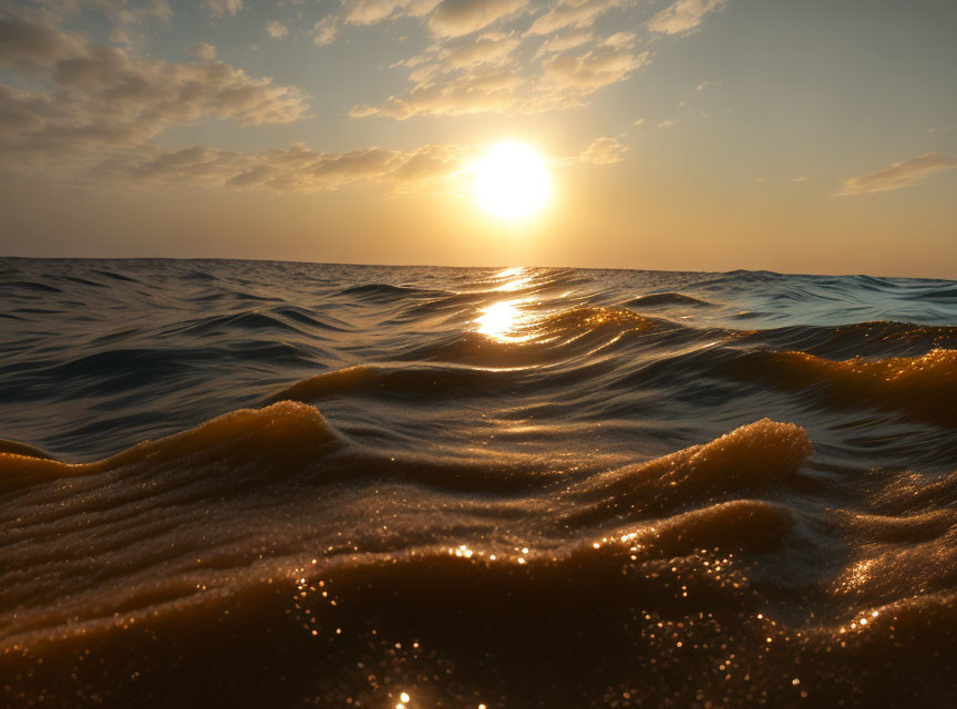 Tranquil sea sunset with gentle cresting waves.