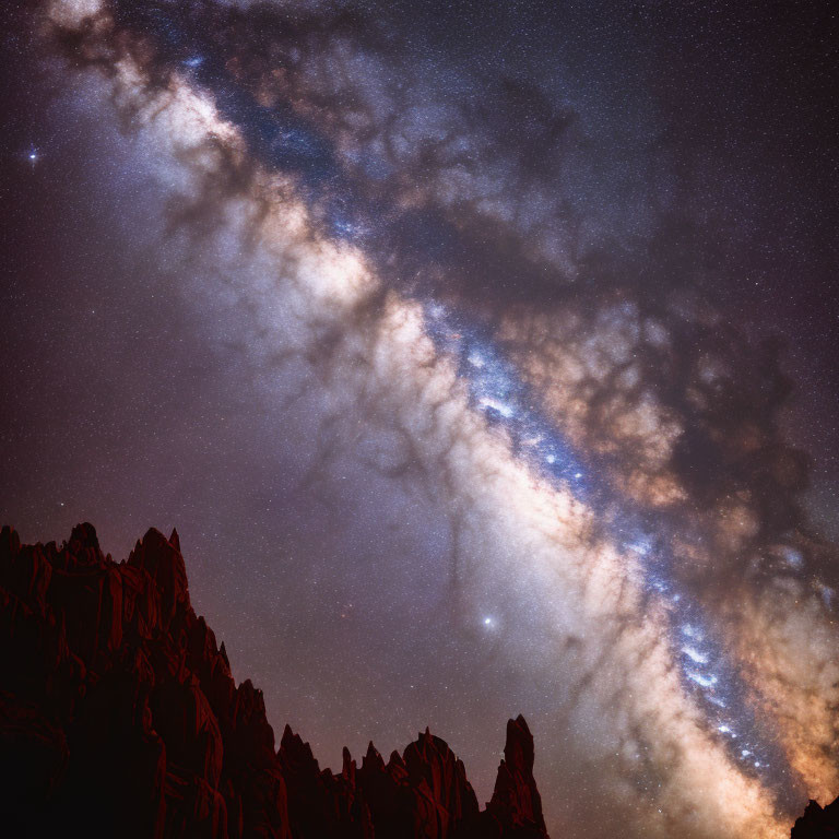 Stunning Milky Way night sky over jagged mountain peaks