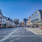 Snowy Vintage Town Street Scene with Lit Streetlamps at Twilight